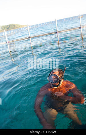 Polynésie Française, Île de Tahaa. Un pêcheur local dans son poisson le long de l'île de Tahaa. Banque D'Images