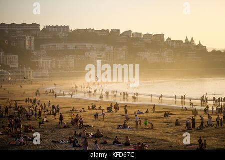 Les gens sur la plage de Concha profitant de la fin de l'après-midi soleil sur une journée d'octobre, San Sebastian, Pays Basque, Espagne. Banque D'Images