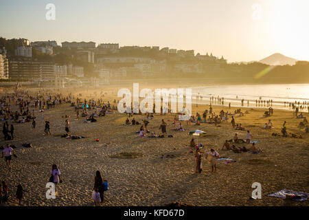 Les gens sur la plage de Concha profitant de la fin de l'après-midi soleil sur une journée d'octobre, San Sebastian, Pays Basque, Espagne. Banque D'Images