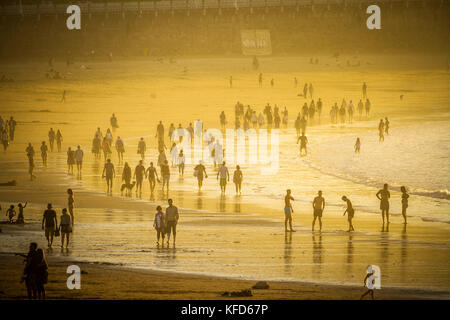 Les gens sur la plage de Concha profitant de la fin de l'après-midi soleil sur une journée d'octobre, San Sebastian, Pays Basque, Espagne. Banque D'Images