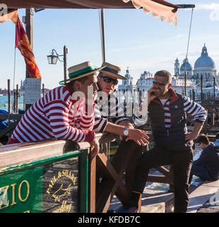 Trois gondoliers Venise Italie Venise gondoliers dans trois chemises traditionnelles en attente à la station de location gondole sur le Grand canal Venise Italie Europe de l'UE Banque D'Images