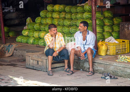 Les hommes assis à la Crawford market à Mumbai, Inde Banque D'Images