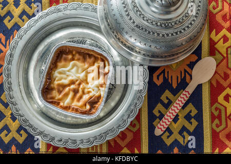 Lieu pudding (muhallebi) dans la plaque vintage avec tapis et cuillère vue supérieure Banque D'Images