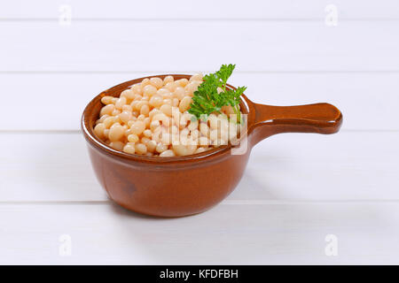 Casserole de haricots blancs en conserve sur fond de bois blanc Banque D'Images