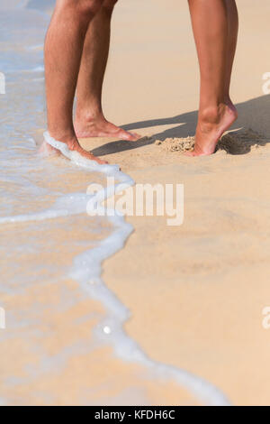 Pattes d'un couple s'embrasser dans l'amour sur une plage de la mer Banque D'Images