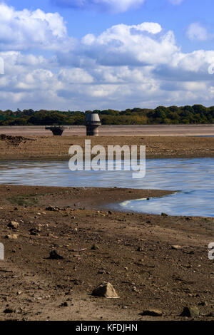 Niveau d'eau bas bewl water reservoir, kent blue sky à la fin de l'été avec les nuages blancs moelleux et coulant avec de la boue de la rive de recul au niveau de la sécheresse Banque D'Images