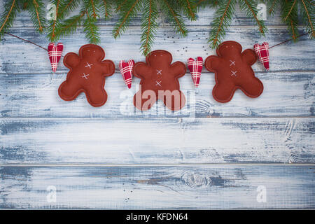 Guirlande de Noël faits à la main avec le gingembre et les hommes des branches d'arbre de Noël sur fond de bois. avec une copie-espace. Banque D'Images