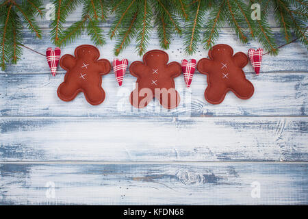 Guirlande de Noël faits à la main avec le gingembre et les hommes à des branches d'arbre de Noël sur le fond en bois rustique. avec une copie-espace. Banque D'Images