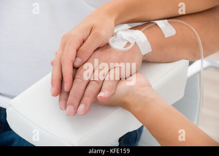 Close-up of a doctor holding main du patient avec perfusion iv Banque D'Images