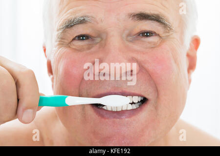 Man se brosser les dents avec une brosse à dents Banque D'Images