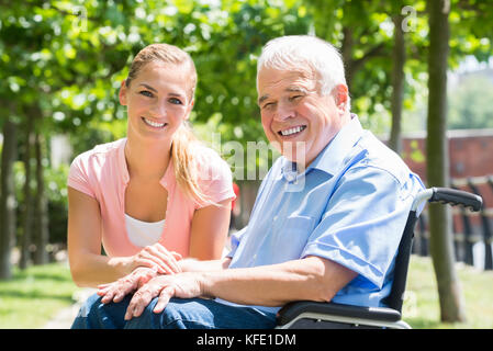 Portrait d'une jeune femme avec son père handicapé sur fauteuil roulant Banque D'Images