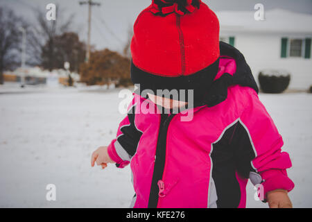 Bébé debout dans la neige portant des vêtements d'hiver Banque D'Images