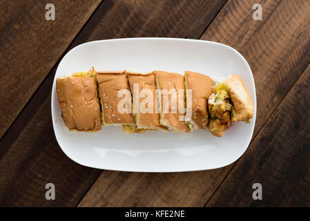 Des spécialités malaisiennes roti (John) - du pain avec l'omelette dans une assiette sur une table en bois Banque D'Images