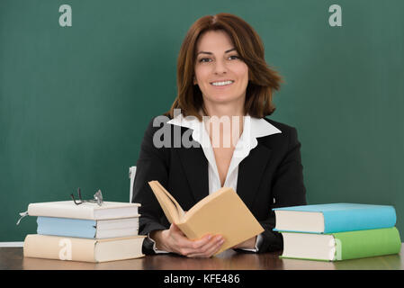 Jeune femme assise à l'enseignant de classe 24 Banque D'Images