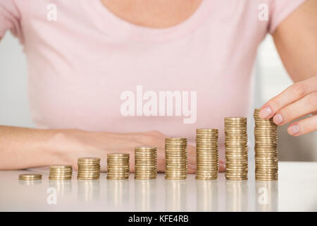 Close-up of Woman Stacking coins à 24 Banque D'Images