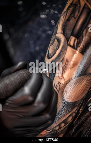 Mains de l'artiste de tatouage tatouage de peau de l'homme Banque D'Images