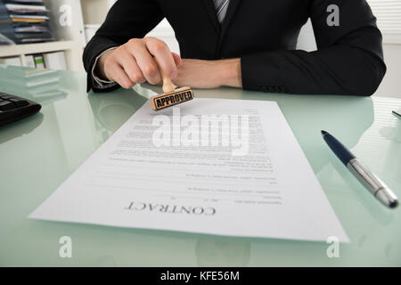 Close-up of businessman hand stamping approuvée le papier du contrat Banque D'Images