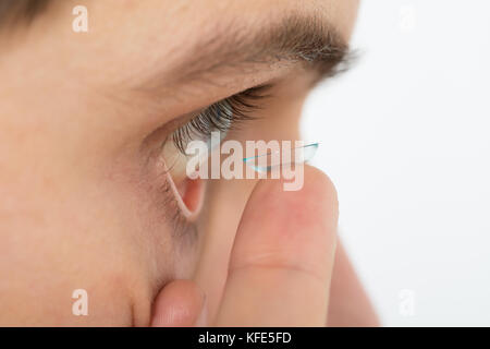 Close-up of Young Man Putting Eye en lentilles de contact Banque D'Images