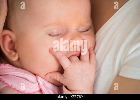 Gros plan d'Un bébé dormant sur le bras de maman Banque D'Images
