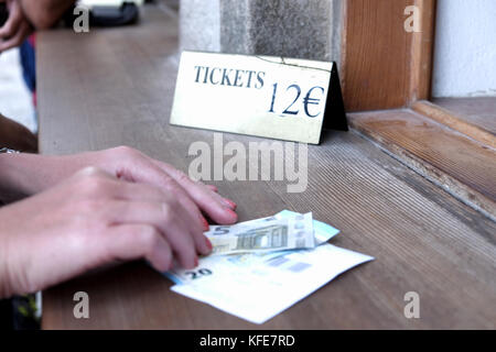 Quelqu'un payant le droit d'entrée pour un billet pour une attraction en euros avec une note de vingt-cinq euros. Acropole de Lindos à Rhodes, Grèce. Banque D'Images