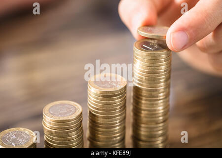 Personne qui met l'entreprise au cours de la pièce de monnaie de plus en plus office de la pile de 24 Banque D'Images