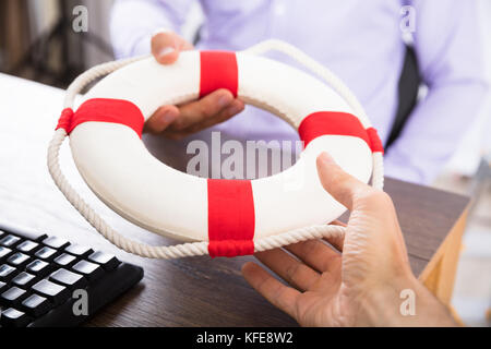 Close-up of a Businessman's Hand passant une bouée à son partenaire dans le bureau Banque D'Images