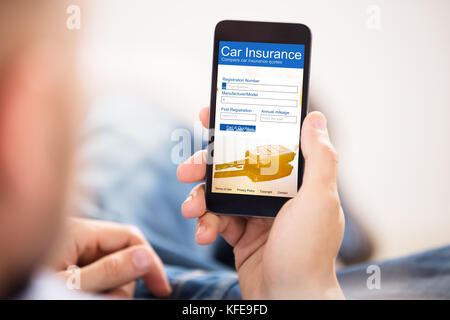 Close-up of a Man Filling auto assurance Formulaire sur téléphone mobile Banque D'Images