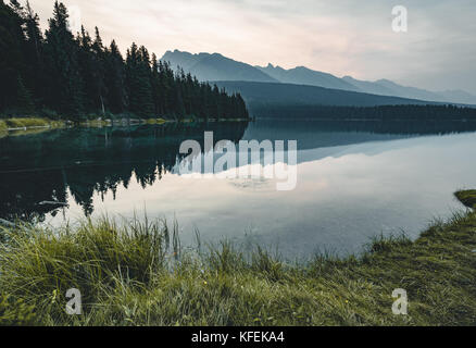 Lever et le matin brumeux sur le mont Rundle au lac en Banque D'Images