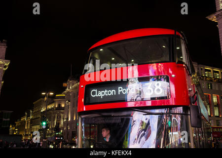 Un bus Routemaster reflétant les lumières de la courbe panneaux publicitaires sur Piccadilly Circus Banque D'Images