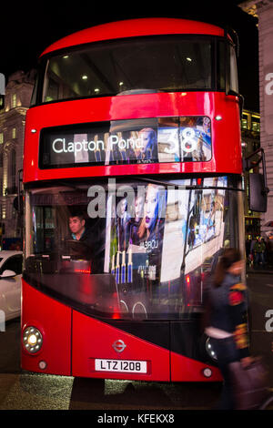 Un bus Routemaster reflétant les lumières de la courbe panneaux publicitaires sur Piccadilly Circus Banque D'Images