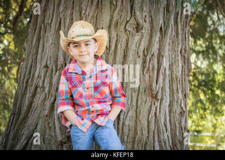 Mixed Race Young boy wearing cowboy hat standing en plein air. Banque D'Images