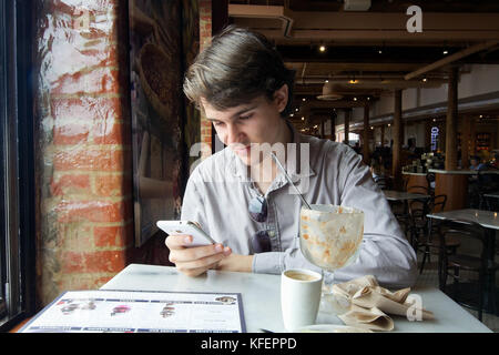 San Francisco, Californie, USA, 08 septembre 2017. Coup franc du jeune homme de sourire et de contrôler le téléphone après avoir consommé un sundae à GH Banque D'Images