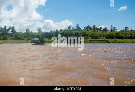 Suva, Fidji, Viti Levu-novembre 28,2016 : travailleur dans l'équipement de construction de creuser dans la rivière Navua avec camion à benne et de la flore tropicale à Suva, Fidji Banque D'Images