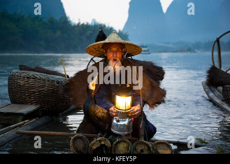 Un vieux pêcheur se prépare pour la pêche de manière traditionnelle à l'aide de la rivière Li au Cormorant près de Xingping, Yangshuo, Guangxi, Chine Banque D'Images