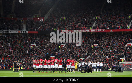 Les joueurs de Manchester United et Tottenham Hotspur observent un silence de quelques minutes pour ceux qui ont donné leur vie dans un conflit armé avant le match de la Premier League à Old Trafford, Manchester. Banque D'Images