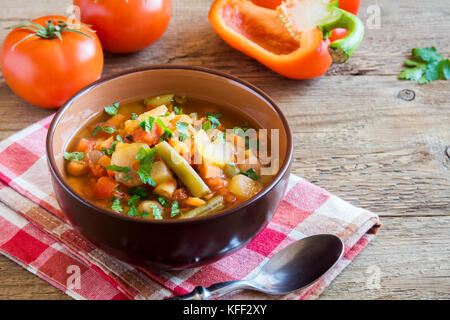 Soupe de légumes avec pommes de terre Tomates Carottes ingrédients poivre Persil Céleri persil Haricots verts sur fond de bois rustique - vega végétarien sain Banque D'Images