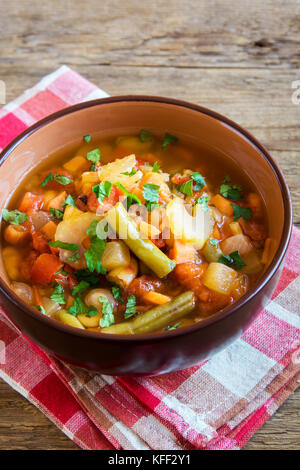 Soupe de légumes avec pommes de terre Tomates Carottes ingrédients poivre Persil Céleri persil Haricots verts sur fond de bois rustique - vega végétarien sain Banque D'Images