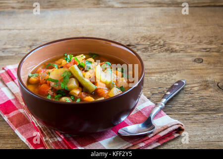 Soupe de légumes avec pommes de terre Tomates Carottes ingrédients poivre Persil Céleri persil Haricots verts sur fond en bois rustique avec copie espace - santé Banque D'Images