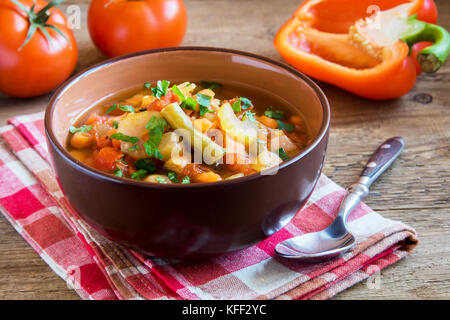 Soupe de légumes avec pommes de terre Tomates Carottes ingrédients poivre Persil Céleri persil Haricots verts sur fond de bois rustique - vega végétarien sain Banque D'Images