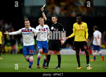 Le réactionnaire de Xherdan Shaqiri de Stoke City, Michael Oliver (deuxième à droite), détient une carte jaune lors du match de la Premier League à Vicarage Road, Watford. Banque D'Images