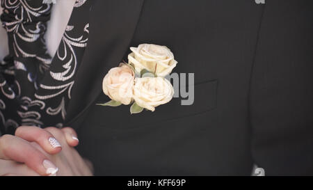 Fleur d'oeillet dans une poche. la fleur dans la poche de la veste. épingle avec des fleurs blanches décoratives épinglées sur la veste du marié. fleur boutonnière dans la poche du marié lors de la cérémonie de mariage Banque D'Images