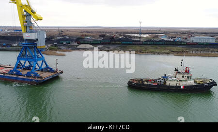 Grues de remorquage pour conteneurs. Grand porte-conteneurs tiré par des remorqueurs. Vue aérienne de haut en bas. Navire de fret de fret de conteneur avec pont de grue de travail dans le chantier naval au crépuscule pour le fond d'exportation d'importation logistique Banque D'Images