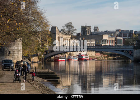 Les gens de New York en promenade en automne sun & profiter de belles rivière par rivière Ouse, Lendal Bridge & New York historique bâtiments au-delà - England, UK. Banque D'Images