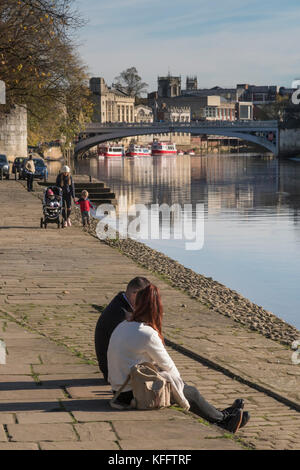 Les gens de York vous détendre dans soleil d'automne et profiter d'une magnifique rivière par rivière Ouse, Lendal Bridge & New York historique bâtiments au-delà - England, UK. Banque D'Images