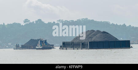 Remorqueur tirant des barges chargées de charbon noir dans la rivière Banque D'Images