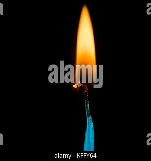 Un plan macro sur une flamme de combustion d'une mèche, tourné sur un fond noir. Banque D'Images