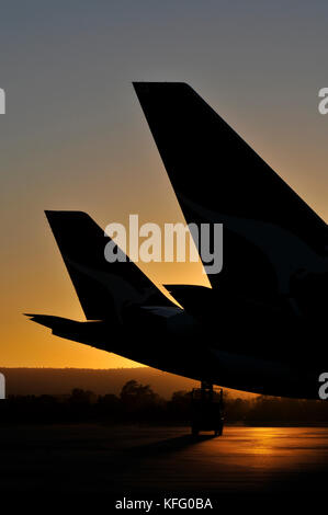 Un portrait de droit au coucher du soleil, la silhouette de queue d'avion dans un aéroport. Banque D'Images
