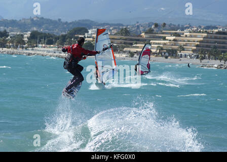 Kiteboarder décoller pour un saut en face de windsurfer. St Laurent du Var, Côte d'Azur Banque D'Images