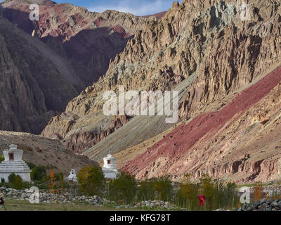 Montagne Rouge vif, des couches de roches alternent avec les autres, dans les contreforts des collines sont blanches stupas bouddhistes, Ladakh, Inde du nord. Banque D'Images