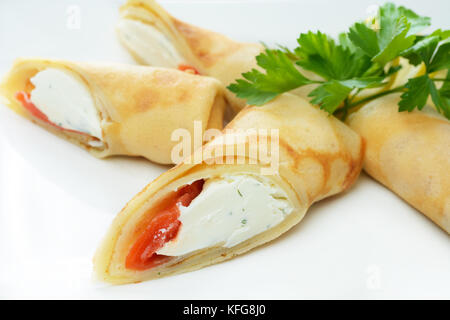 Des crêpes au fromage et saumon grillé sur plaque blanche Banque D'Images